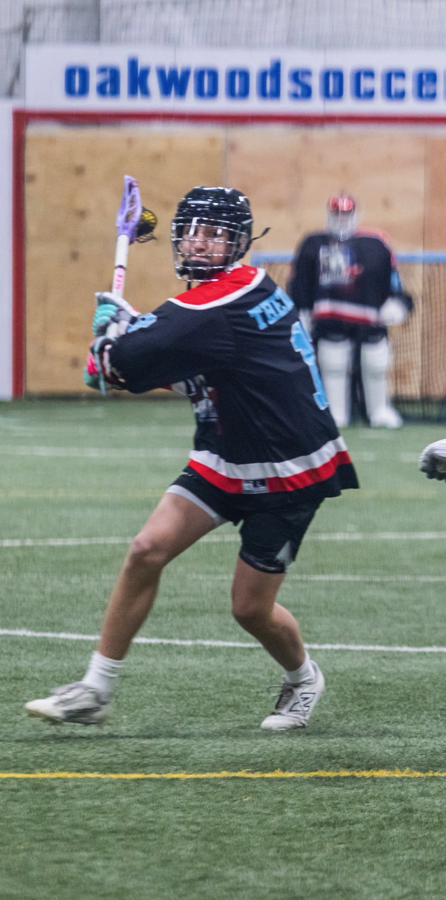 Kougarz box lacrosse player winding up for a shot on goal